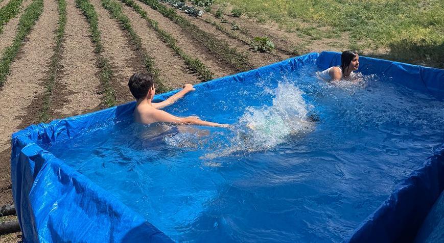 Sıcaklar bunalttı, traktörünü torunları için havuza çevirdi